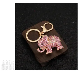 Macro view of pink rhinestone elephant keychain with gold hardware on dark background
