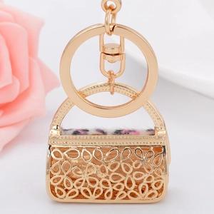Macro detail of golden handbag keychain with leopard print fur and lobster clasp