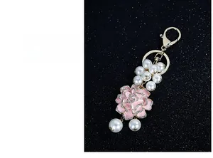 Détails de l'anneau porte-clés camélia en émail rose avec perles et cristaux