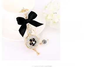 Detail of luxury alloy keychain featuring camellia flower, pearl beads and Eiffel Tower
