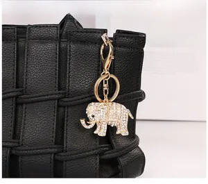 Detail of crystal-encrusted elephant keychain with gold lobster clasp on black bag