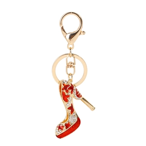 Elegant gold-tone stiletto keychain with red enamel coating and sparkling rhinestones