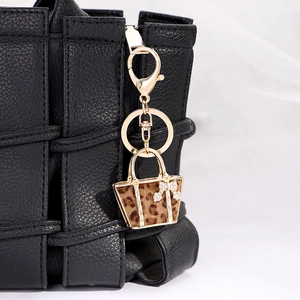 Chic leopard print mini handbag keychain with gold metal frame and sparkling rhinestone bow
