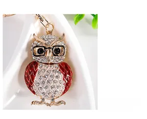 Détail du porte-clés hibou avec ailes en émail rouge et strass sur alliage doré brillant