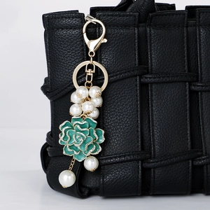 Porte-clés camélia en émail vert avec des perles blanches et des strass brillants