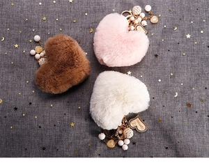 Détail d'un porte-clés cœur en peluche avec étiquette I love you, perles et boules