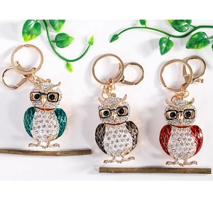 Gros plan détaillé des porte-clés hibou en cristal de couleurs verte, noire et rouge