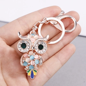 Portachiavi gufo di lusso in oro rosa con pietre occhio di gatto e strass in mano