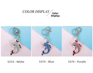 Three crystal dolphin keychains with crowns in blue, pink, and silver finishes
