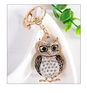 Détail du porte-clés hibou doré avec cristaux blancs et détails en émail noir