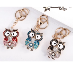 Detail of owl crystal keychains in red, blue and black with sparkling rhinestone inlay