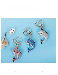 Detailed view of dolphin keychains with colorful rhinestones and crown accents