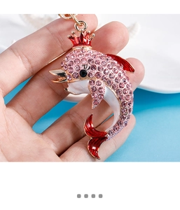 Close-up of dolphin charm with pink crystals, red crown and metallic key ring