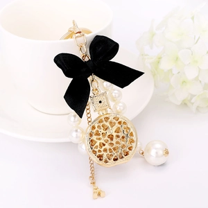 Golden perfume bottle keychain with black ribbon bow, pearls and Eiffel Tower charm