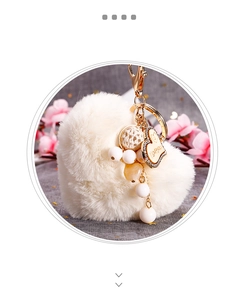 Détail de porte-clés cœur en peluche avec breloque dorée et texture en fausse fourrure