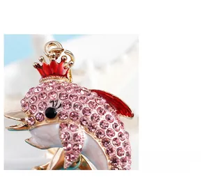 Detail of pink crystal dolphin keychain with red crown and polished gold finish