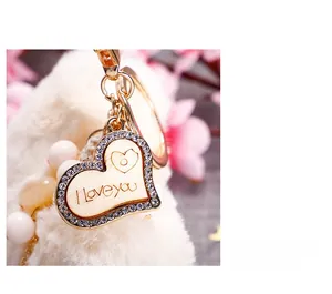 Détail d'un porte-clés cœur en peluche avec pendentif doré I Love You et strass brillants