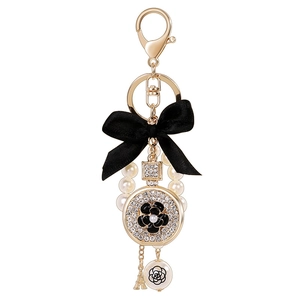 Bow perfume bottle keychain with gold Eiffel Tower and camellia pearl charm