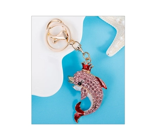 Detail of pink crystal dolphin keychain with red crown and gold ring hardware