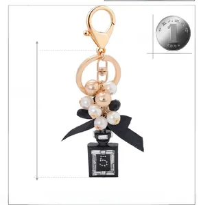 Dettaglio del portachiavi a boccetta di profumo con perle da 13cm con dimensioni e moneta