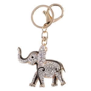 Sparkling elephant keychain pendant with crystals and golden finish on white background