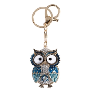 Sparkling owl keychain with blue rhinestones and white enamel details on gold plating