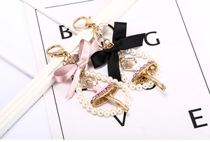 Détail du porte-clés ballerine avec anneau de perles et nœud élégant en satin rose