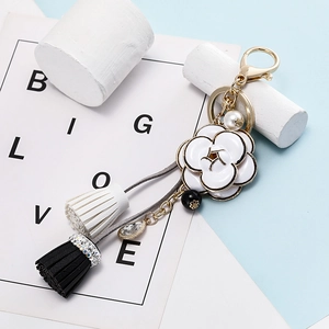 Détail du pendentif camélia avec franges en cuir et élégant accent de perles