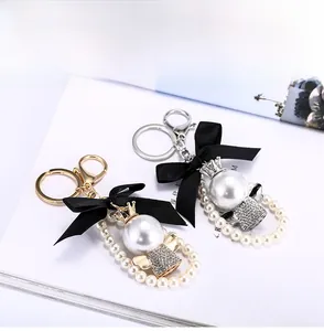 Detail eines Perlenkronen-Schlüsselanhängers mit goldenem Karabiner und Strass-Akzenten