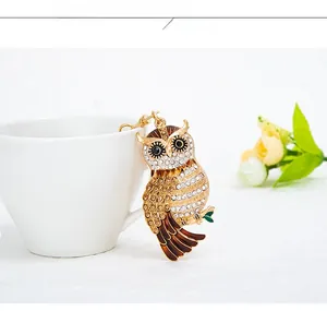 Détail du porte-clés hibou en strass sur une tasse en porcelaine, breloque de luxe dorée