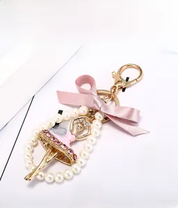 Détail du porte-clés ballerine avec strass roses, nœud en satin et perles blanches