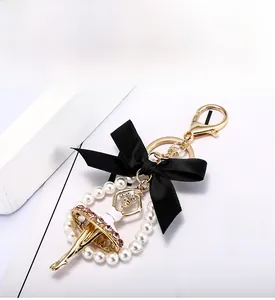 Détail du porte-clés danseuse de ballet avec strass roses, nœud noir et perles