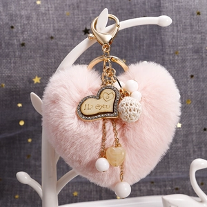 Porte-clés cœur en peluche rose avec pendentif en bois et métal doré sur branche