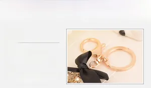 Detail of rose gold keychain with black ribbon bow and elegant pearl chain ornament