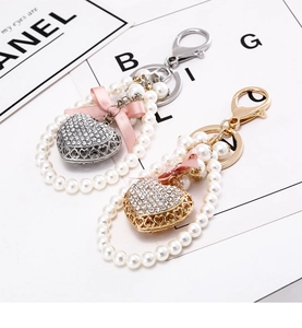 Close-up of pearl heart keychains with crystal charms and pink ribbon bows