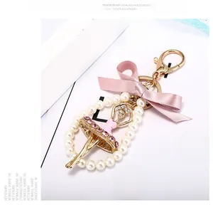 Détail macro du porte-clés fille ballerine avec nœud en soie rose et bague en perle