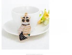 Gros plan détaillé d'un porte-clés hibou de luxe avec strass sur une tasse en céramique