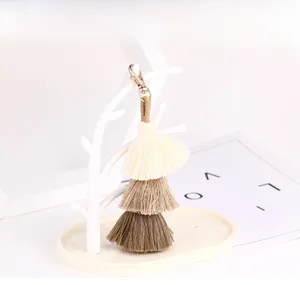Detail of three-tier gradient earth tone tassels with a golden metal lobster clasp