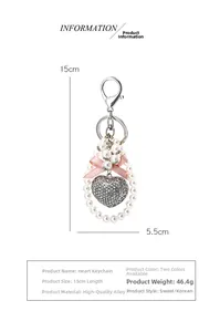 Detail view of heart keychain with pink silk bow, pearls and diamond-encrusted heart pendant