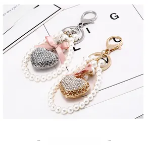 Detail of crystal heart keychain with pearls and pink bow in gold and silver finish