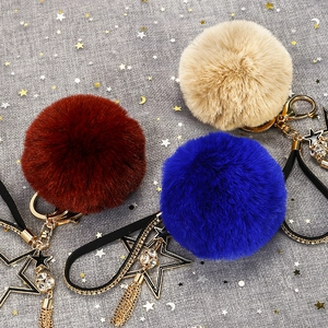Schlüsselanhänger mit Kunstfell-Pompon, Sternenanhänger und Quaste im Glamour-Stil