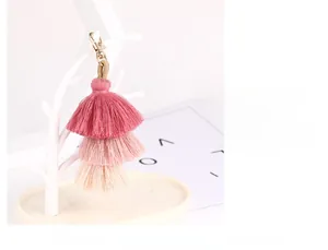 Detail showing the pink gradient three-layer tassel with a gold lobster clasp