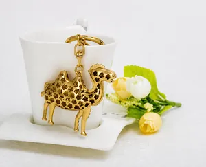 Nahaufnahme des goldenen Kamel-Schlüsselanhängers mit Blumenmuster an Teetasse