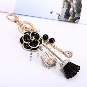 Porte-clés camélia de luxe avec perles et pompons en cuir sur un magazine de mode