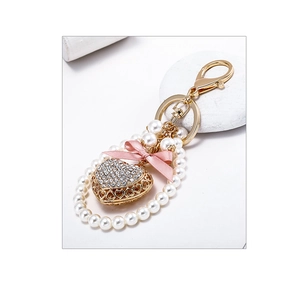 Close-up of a pink silk bow and heart pendant with rhinestones and white pearls