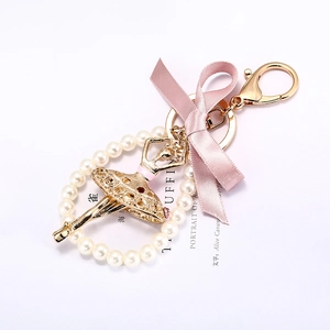 Porte-clés ballerine élégant avec nœud rose et perles blanches sur clip doré