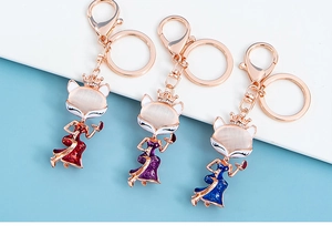 Detailed trio of fox keychains with cat-eye stones and crowns in red, blue, and purple