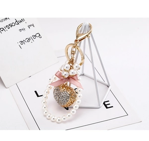 Detail of heart keychain with pink ribbon, white pearls, and sparkling rhinestones