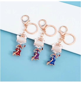Three Chinese style enamel fox keychains in red, blue, and purple with cat-eye stone detail