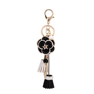 Porte-clés camélia élégant avec chaîne de perles blanches et accents dorés de luxe